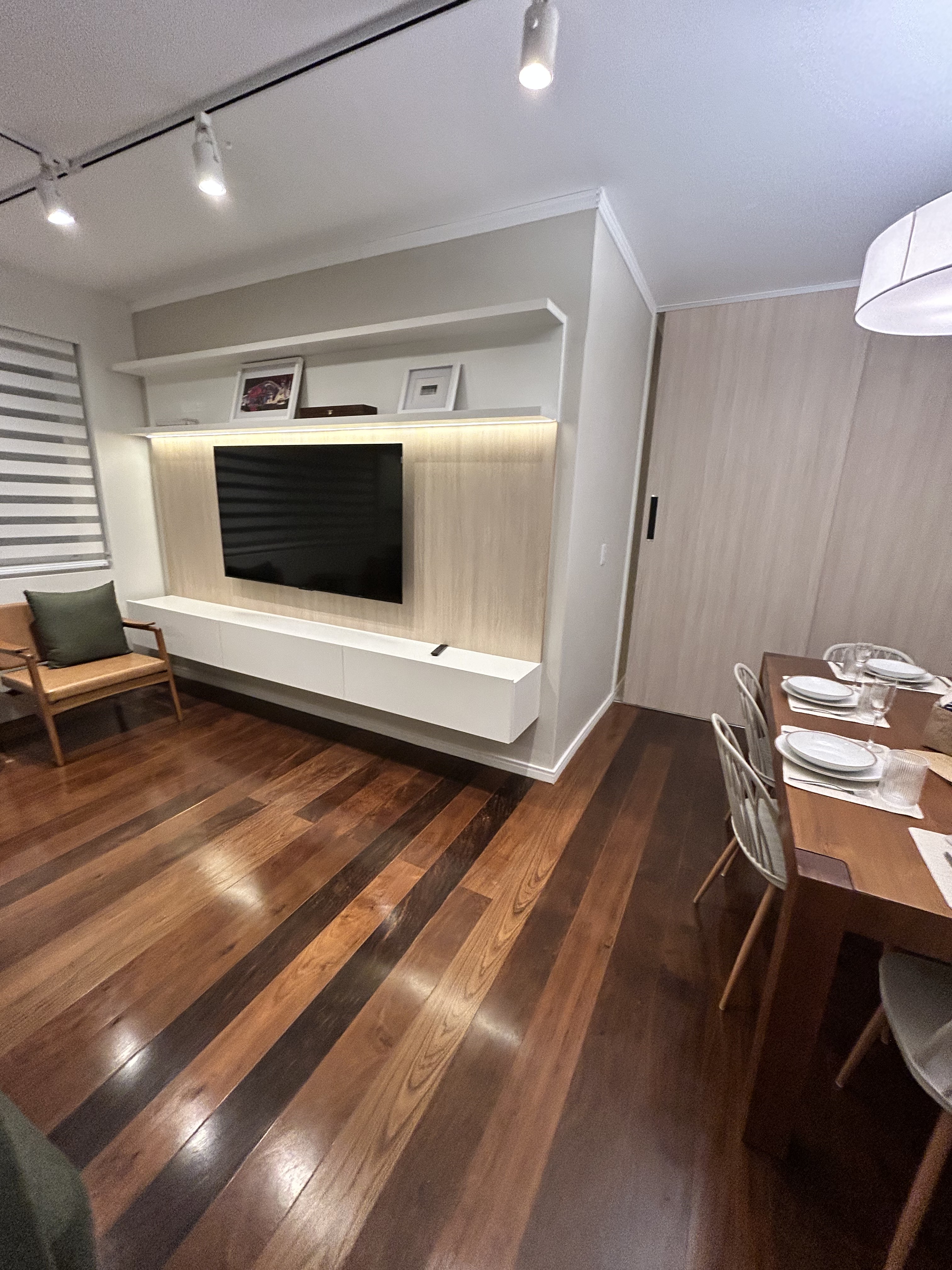 Living com painel e piso de madeira